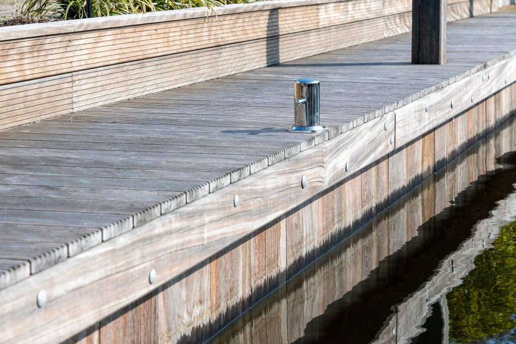 Betonnen kademuur met stalen meerpalen langs watergang, professionele waterbouwkundige constructie