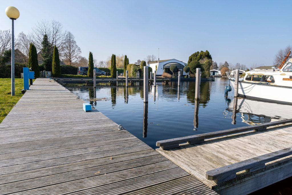 Moderne aanlegsteiger met drijvende pontons en meerpalen voor bootligging aan het water