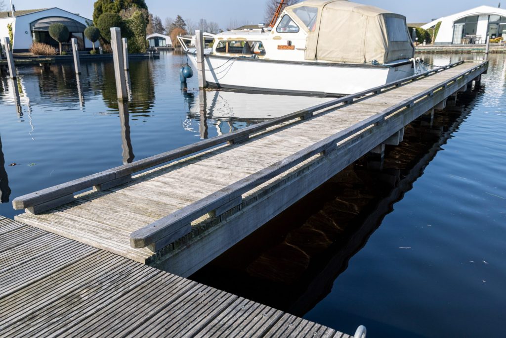 Drijvende pontons aangelegd in jachthaven voor aanlegsteiger met betonnen vlonders en aluminium reling