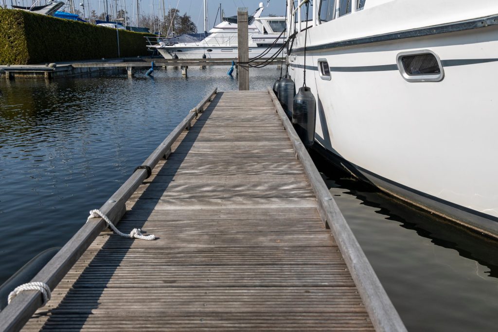 Houten steiger met aangemeerde boten in jachthaven, geschikt voor aanleg en onderhoud van ligplaatsen