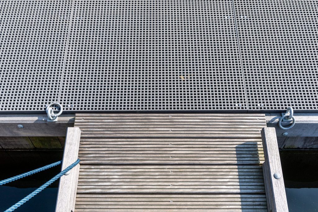 Aanlegsteiger met antislip loopdek en afmeertrap bij water, veilige toegang tot boot