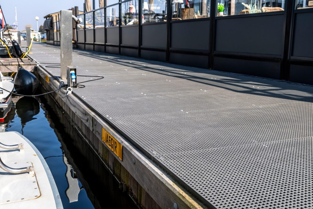 Stalen vlonder met getraand antislip loopvlak voor veilige toegang langs waterkant met veiligheidshekwerk
