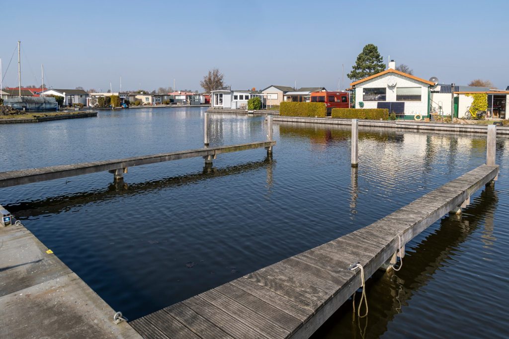 Drijvende pontons en houten steigers in jachthaven met ligplaatsen voor boten en recreatievaartuigen