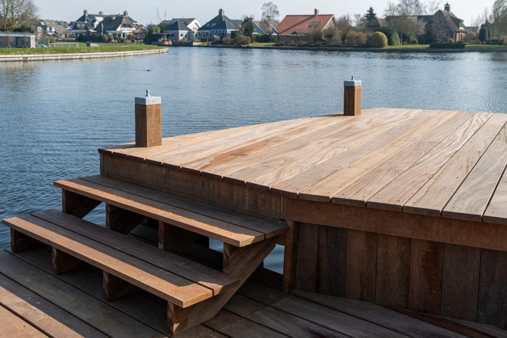 Houten steiger met ingebouwde trap aan het water, aangelegd door Bouma Waterwerken