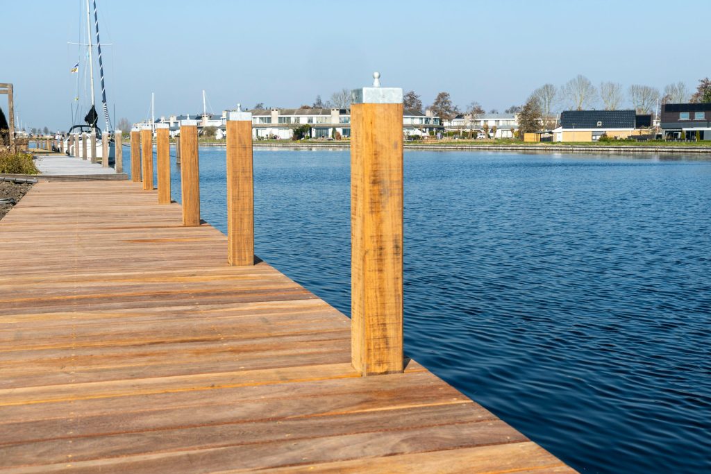 Houten steiger met meerpalen in het water, professioneel aangelegd door waterbouwspecialist