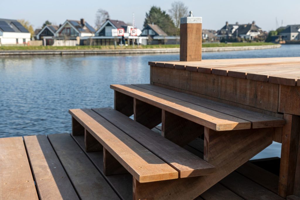 Houten steiger met ingebouwde trap aan het water, aangelegd door Bouma Waterwerken