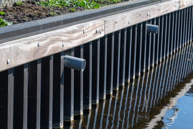 Geplaatste stalen damwand met houten afwerking langs watergang voor waterkering en oeverbescherming